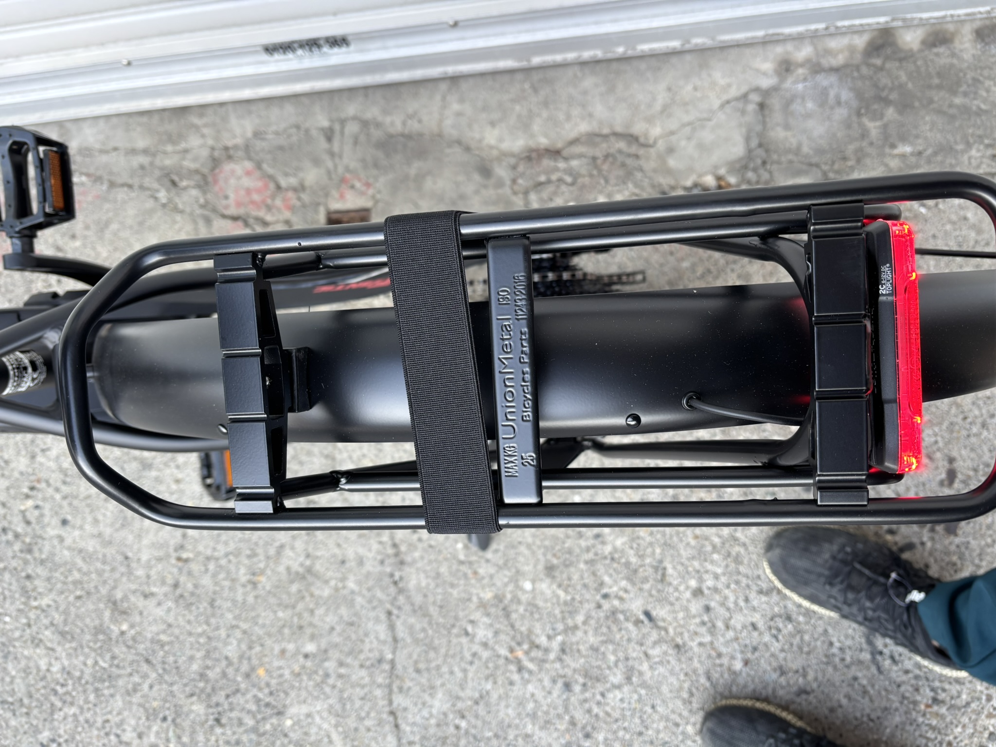 リアキャリアは美しくブラック塗装されたスチール製。最大積載量は25㎏と力強い仕様ですね。荷物固定ベルトが付属しています。